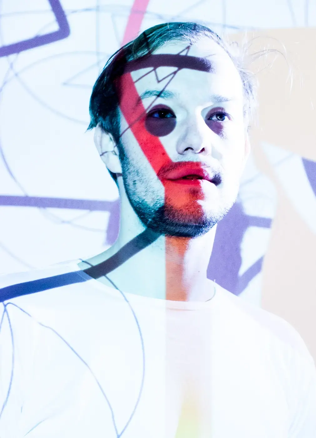 Mann mit abstrakter, bunter Grafikprojektion im Gesicht