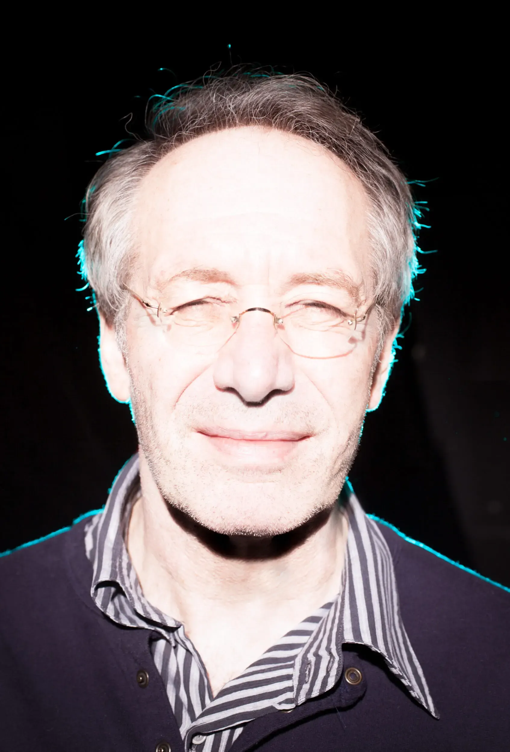 Portrait von Robert Hunger-Bühler mit Brille vor violettem Hintergrund