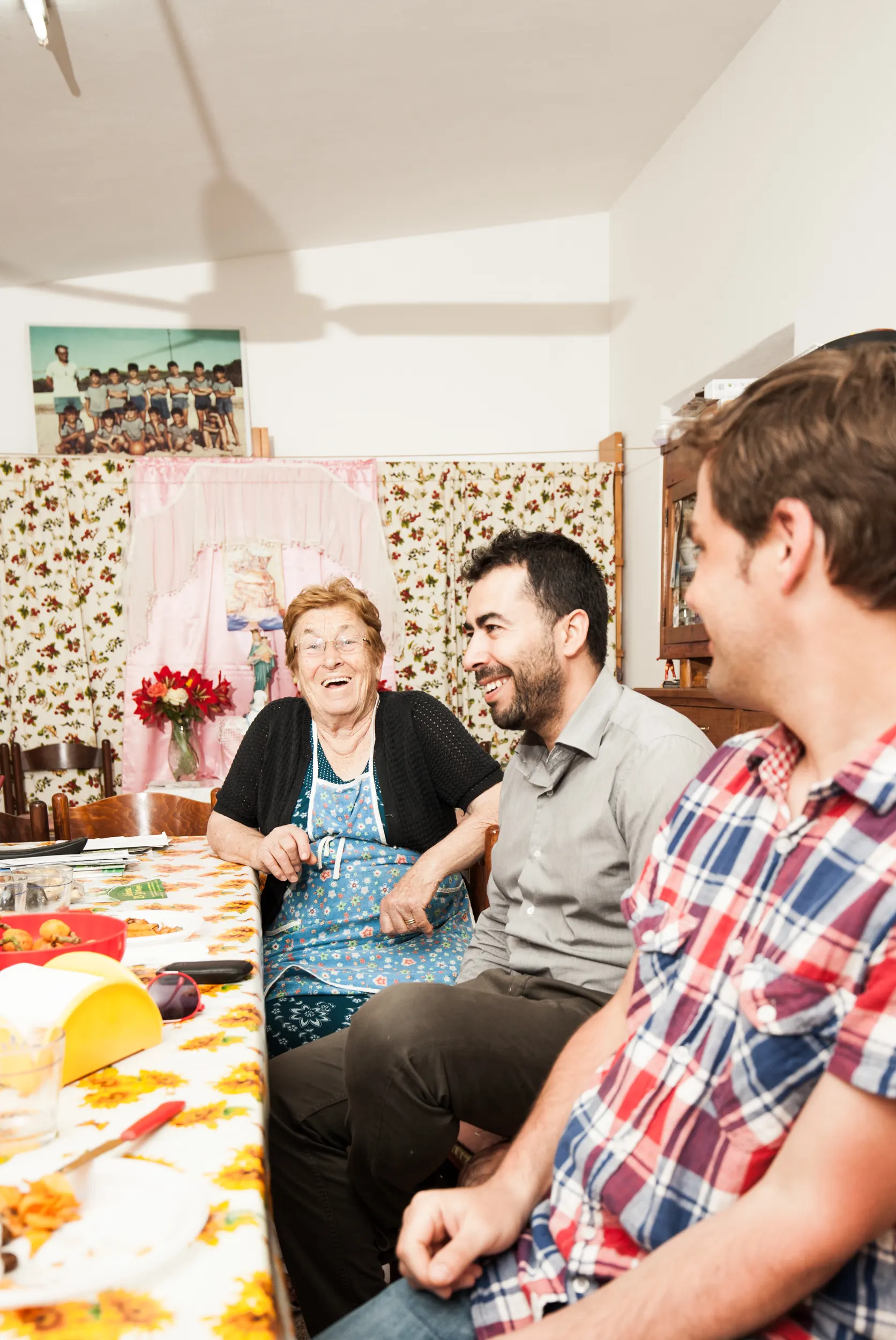 Familie sitzt gemeinsam am gedeckten Tisch, Sardasol