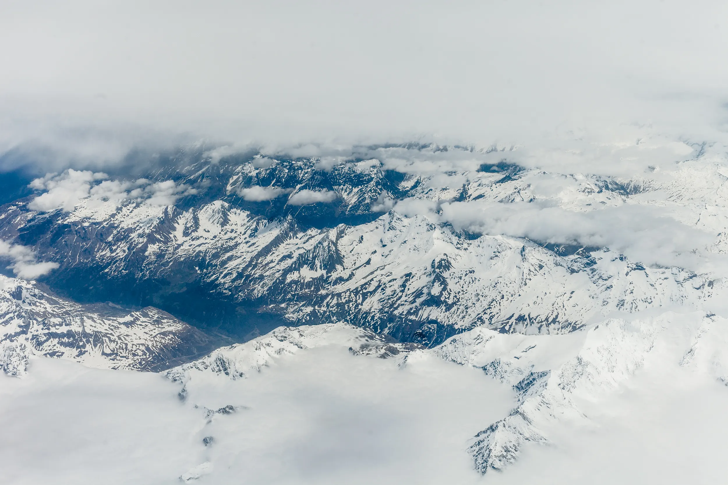 Luftaufnahme schneebedeckter Berge über den Wolken, Sardasol