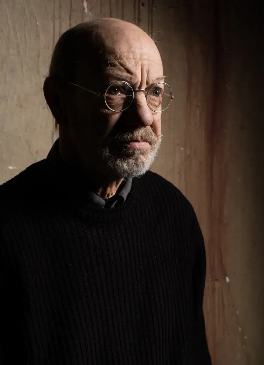 Portrait von Siggi Schwientek mit Brille vor dunklem Hintergrund