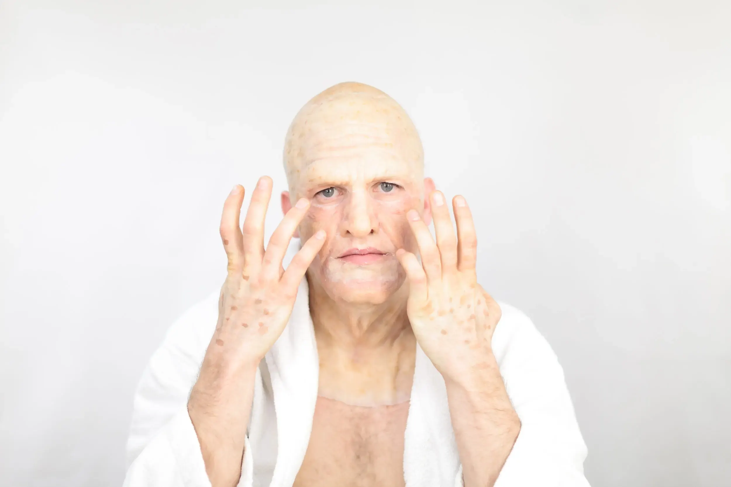 Bühnenfoto aus „Die schönsten Sterbeszenen der Oper“: Mann mit erhobenen Armen in weissem Gewand