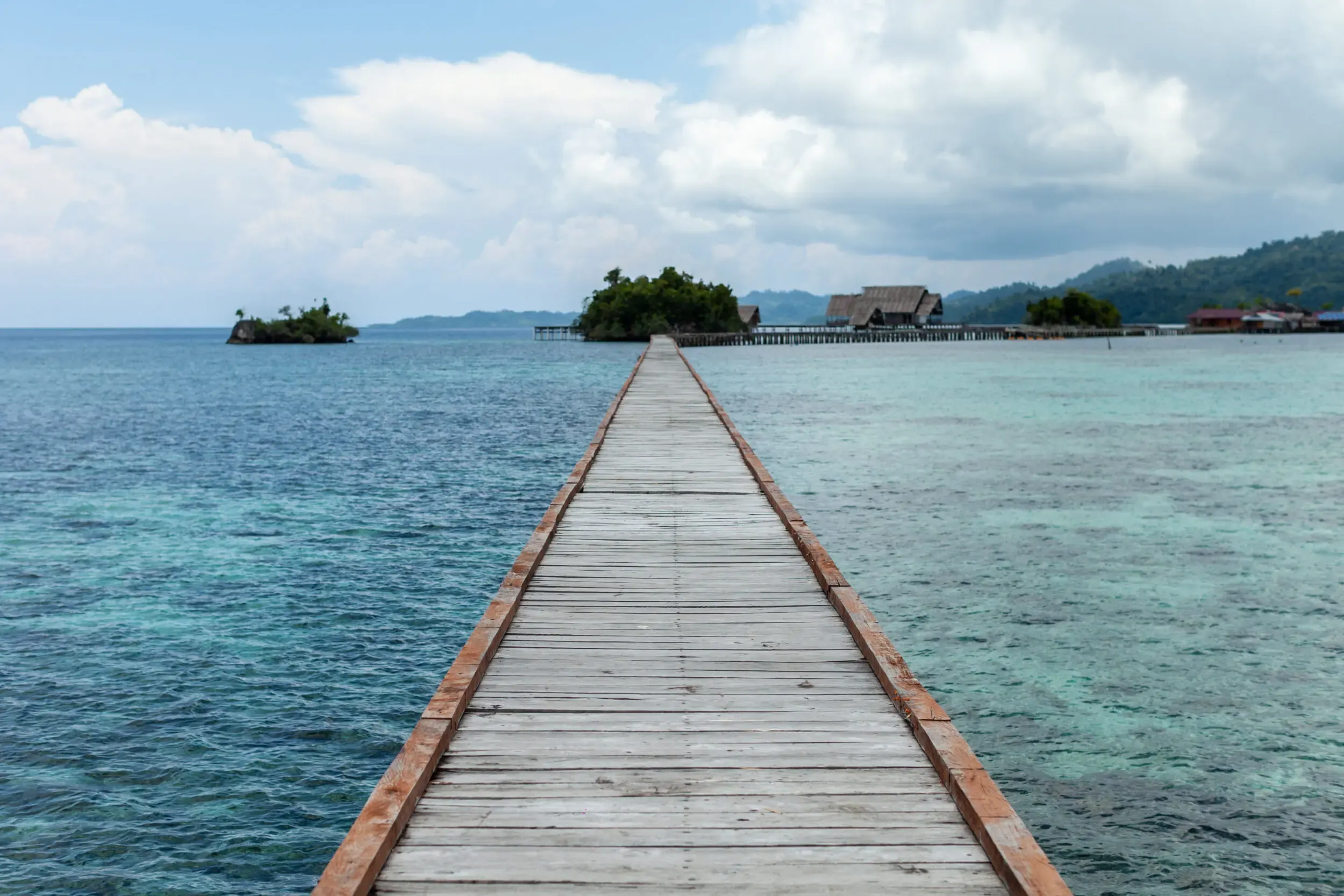 Holzsteg führt zu einer kleinen Insel, Sulawesi