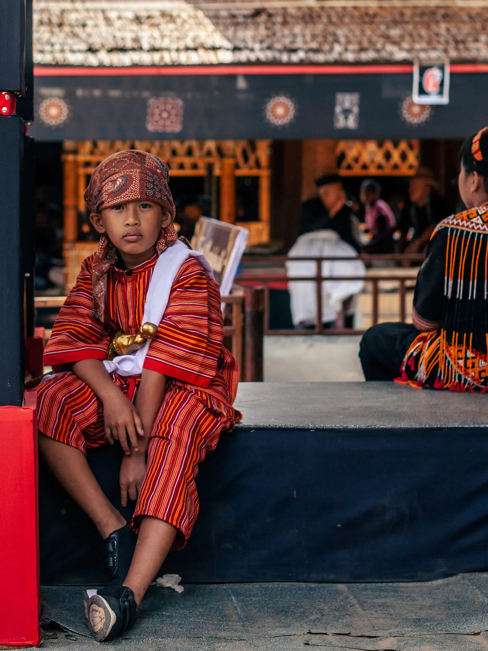 Kind in traditioneller roter Tracht, Sulawesi