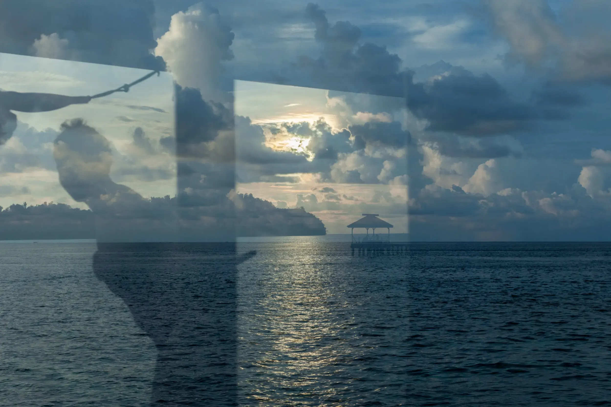 Meerblick durch ein Bootsfenster mit dramatischem Himmel, Sulawesi