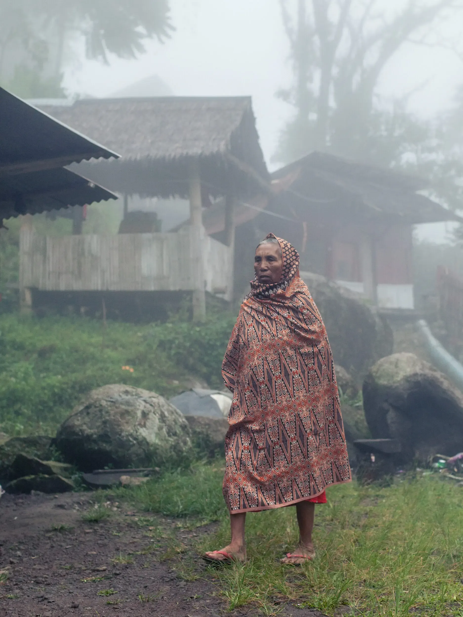 Person in traditioneller Kleidung im nebligen Feld, Sulawesi