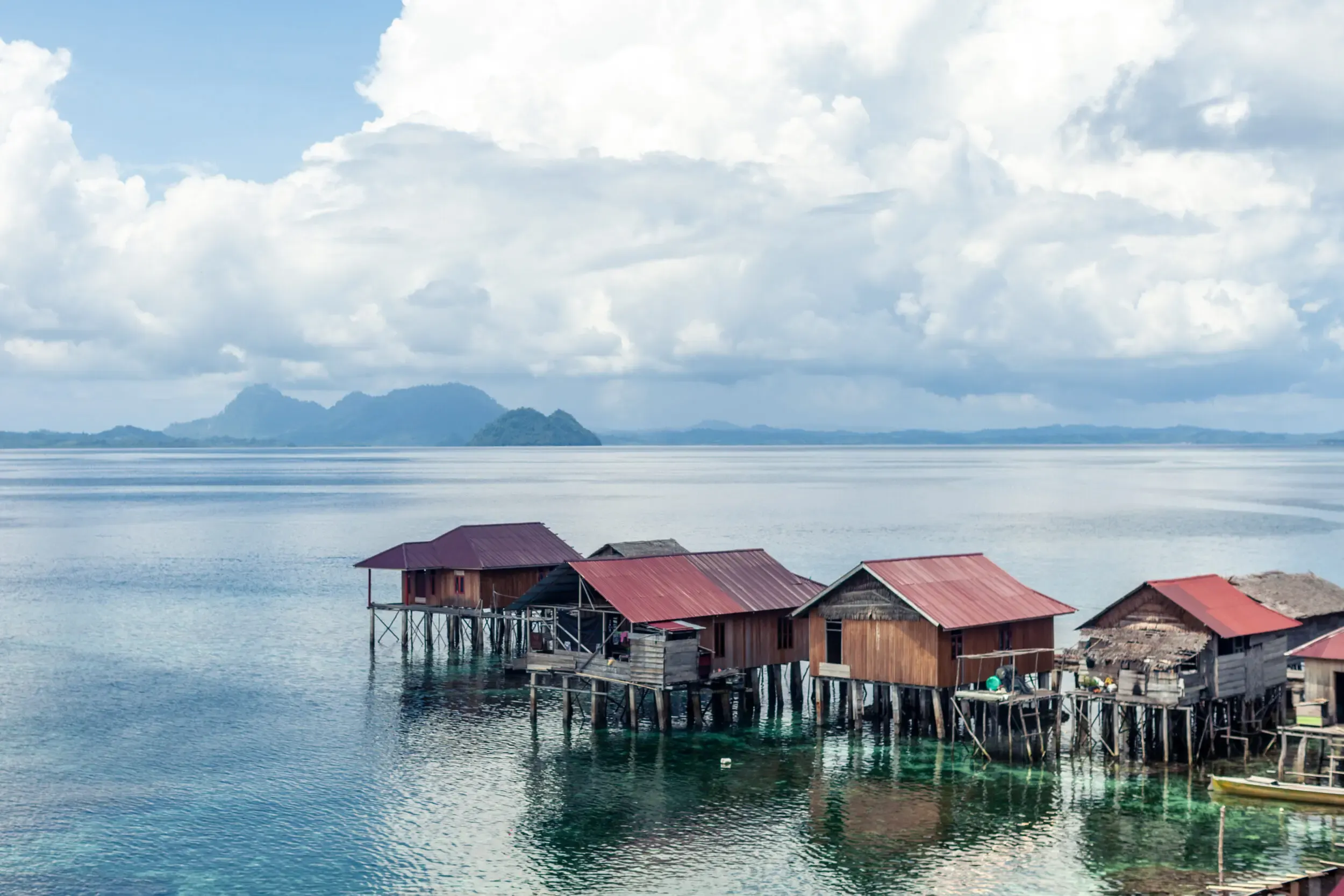 Pfahlbausiedlung am Wasser mit Insel im Hintergrund, Sulawesi