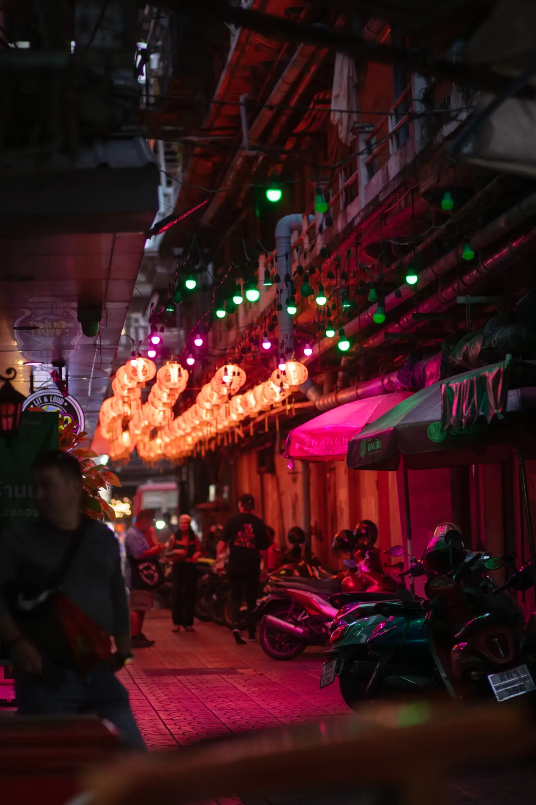 Bunt beleuchtete Gasse mit Lichterketten bei Nacht