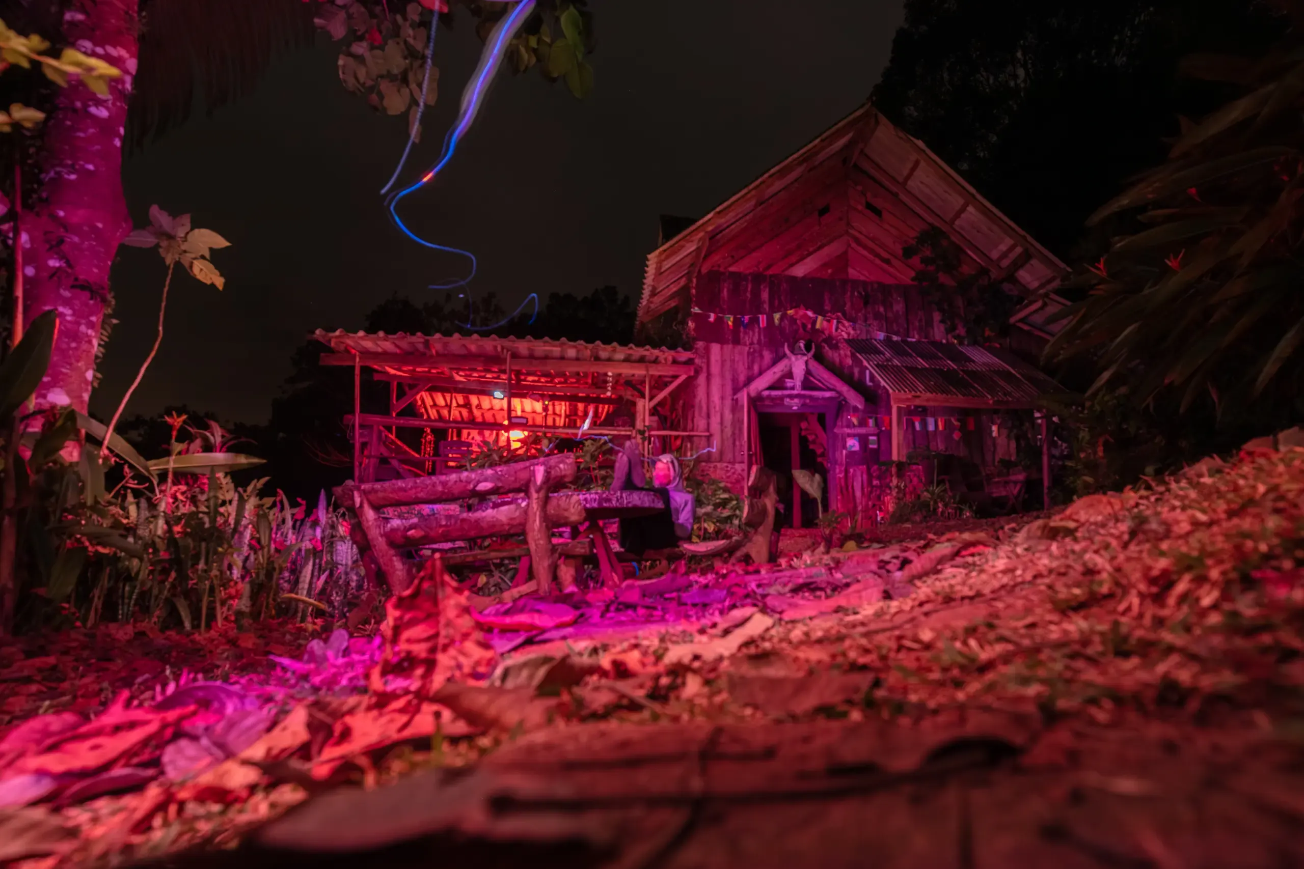 Traditionelles Haus in pinkes Licht getaucht bei Nacht