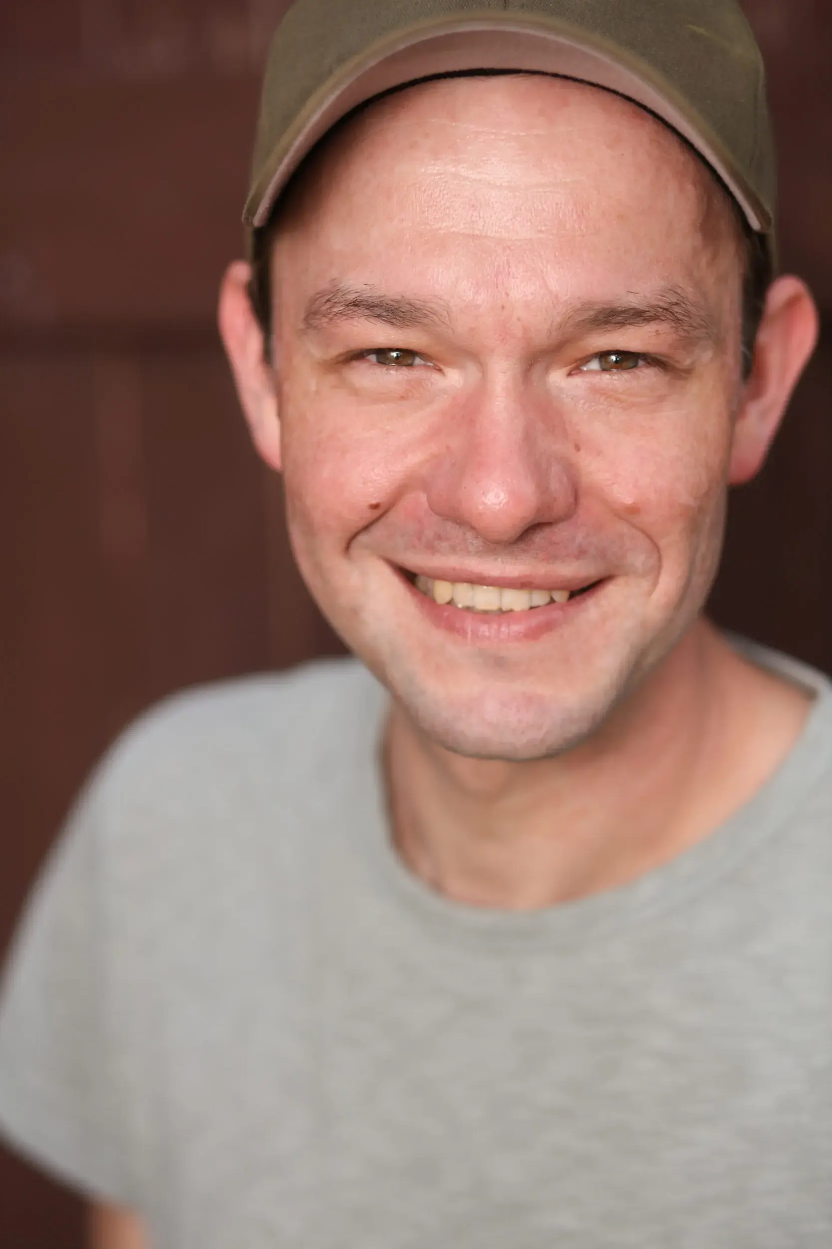 Lächelndes Portrait von Tim Wildner mit Mütze