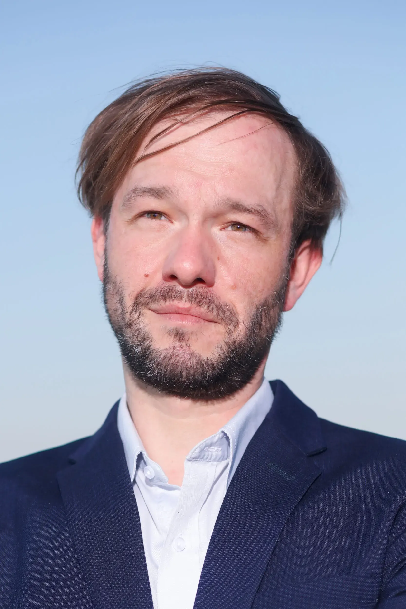Portrait von Tim Wildner vor blauem Himmel