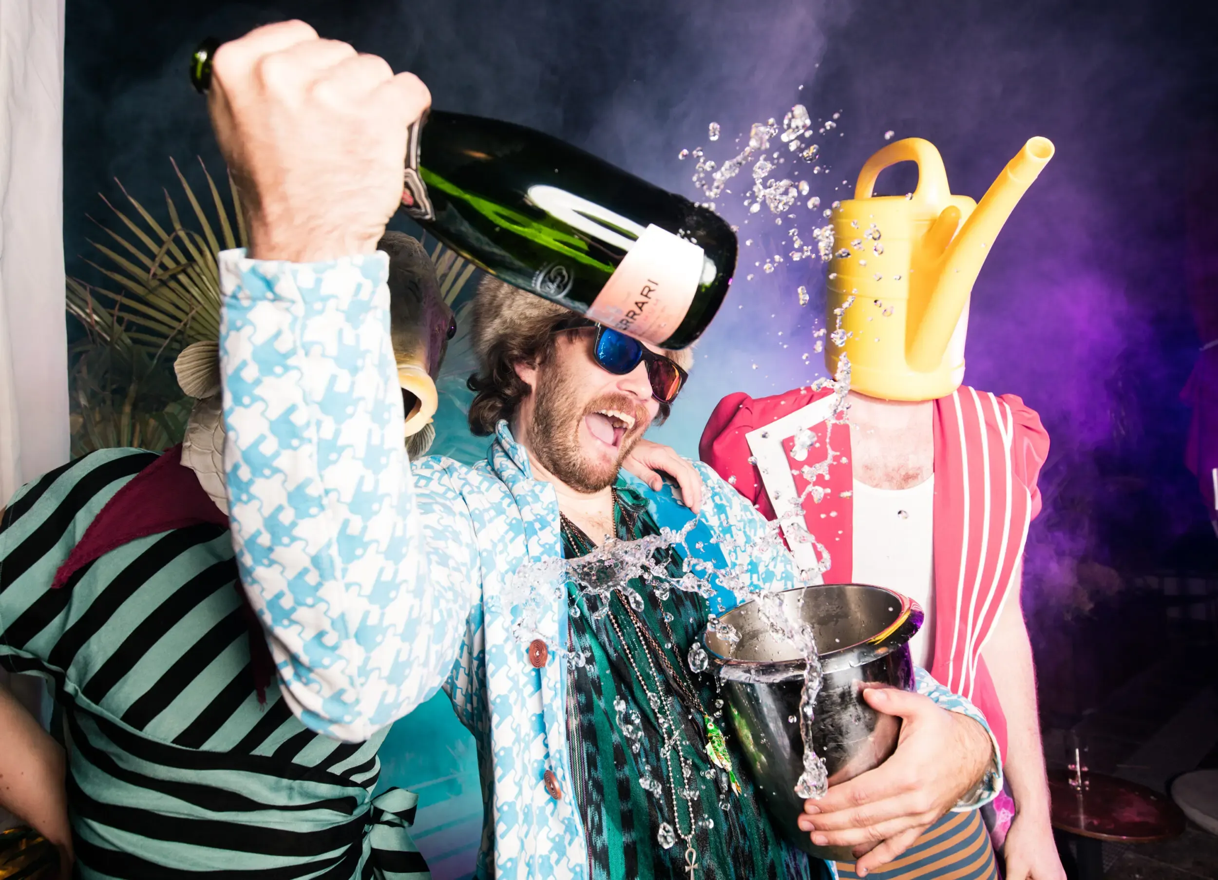 Gruppe feiert ausgelassen mit Champagner in Kostümen