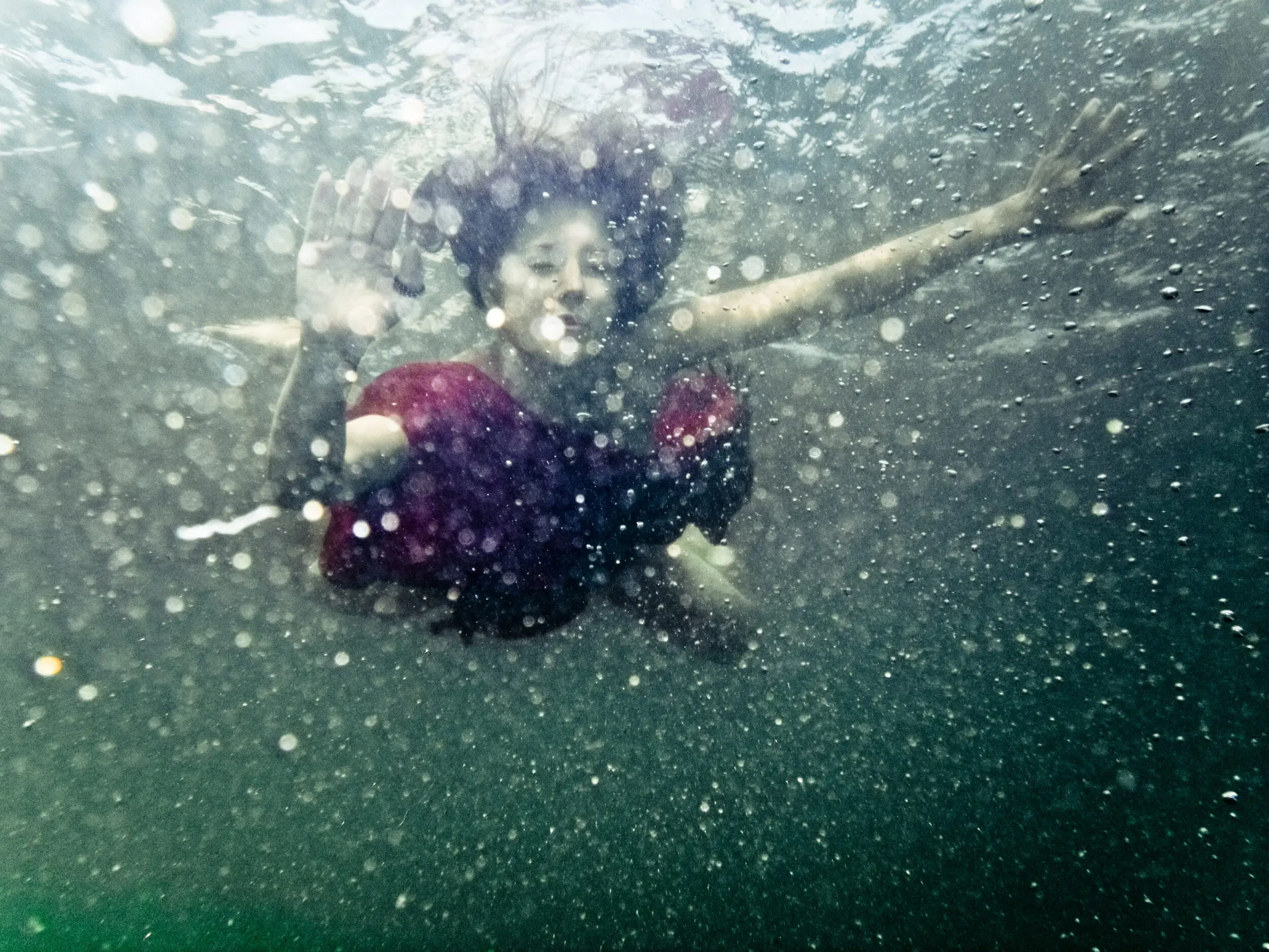 Person springt von oben ins Wasser, under(water) love