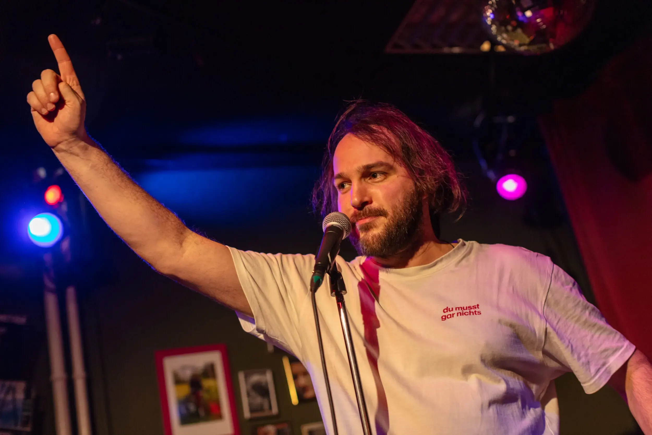 Valerio Moser performt mit erhobenem Arm auf der Bühne