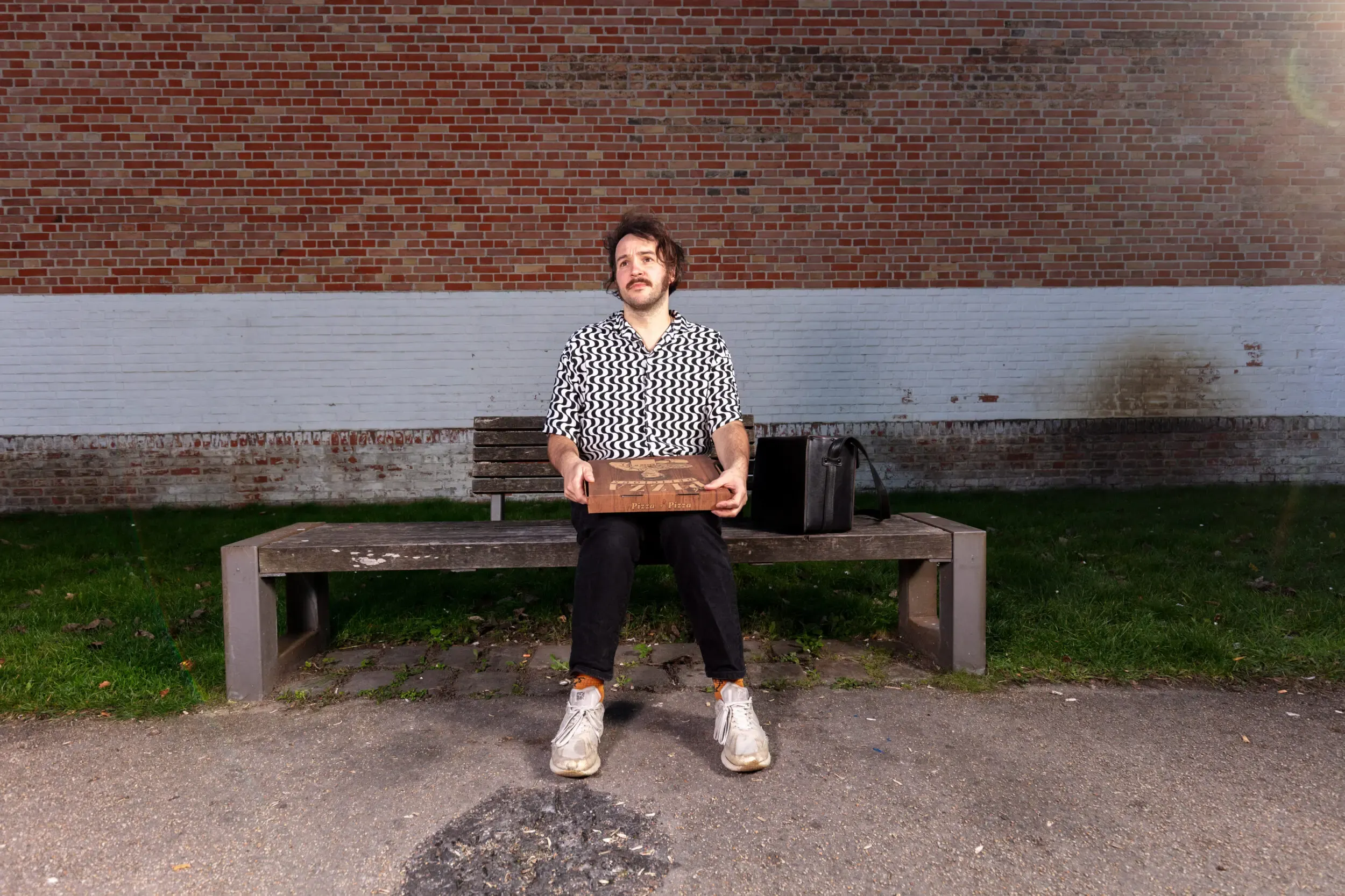 Valerio Moser sitzt auf einer Bank im Park