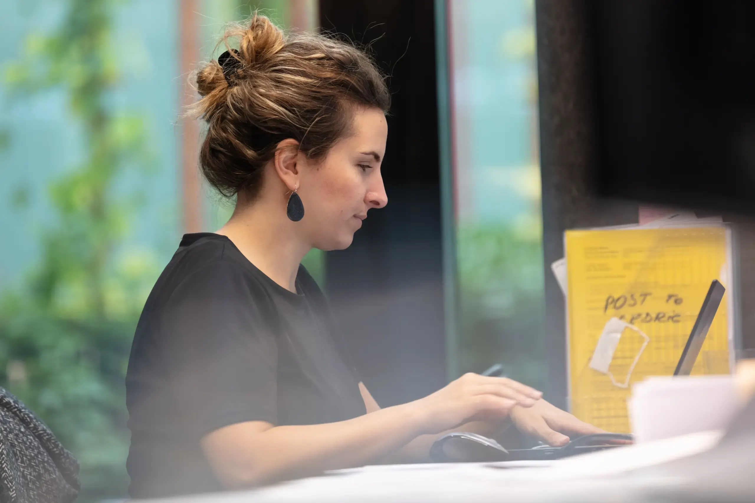 Frau im Profil tippt an einem Schreibtisch vor grünem Hintergrund, Verve Ventures