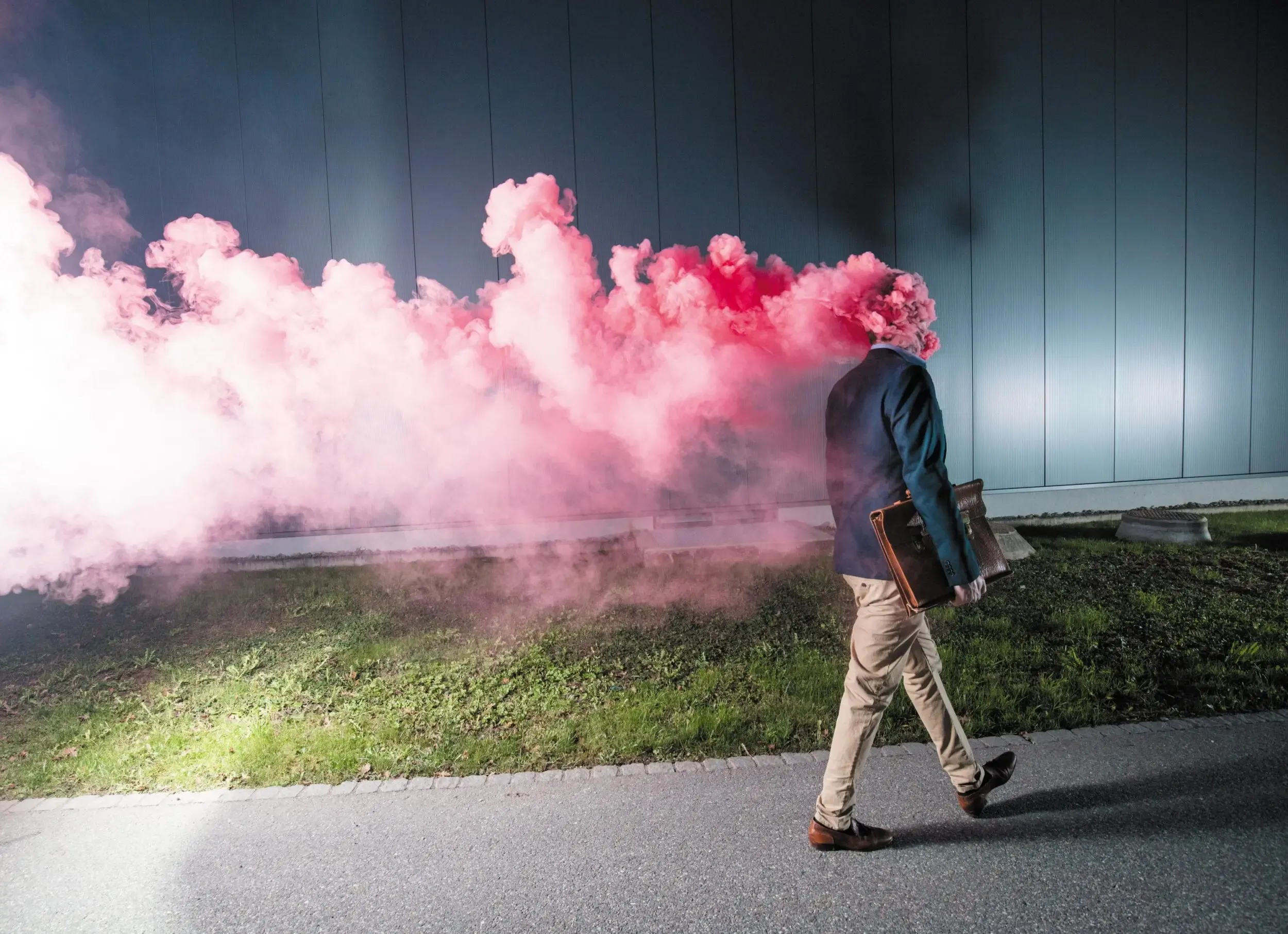 Bühnenfoto aus „Viel gut essen“: Mann geht durch rosa gefärbten Rauch