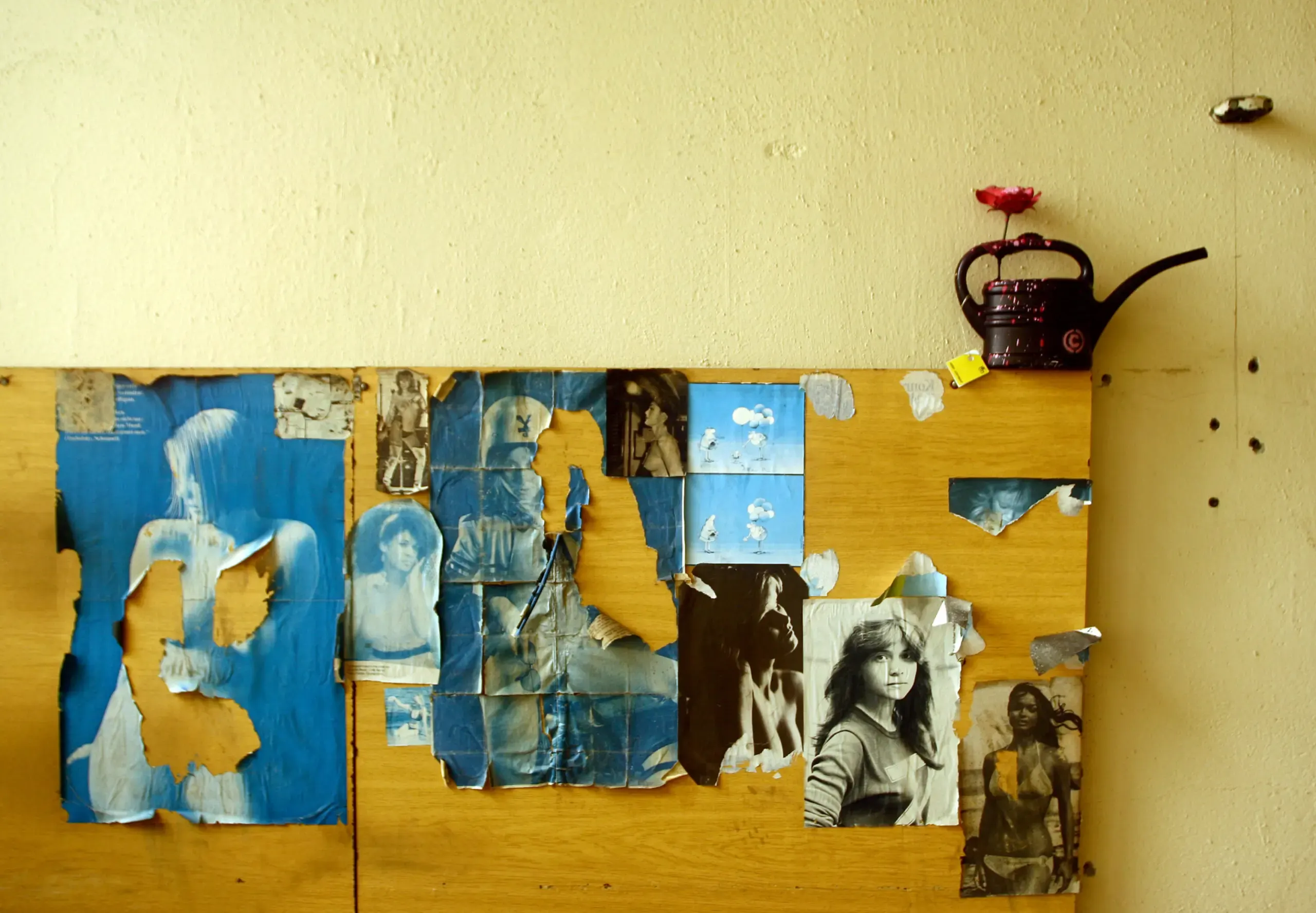Collage aus Fotografien mit kleiner Can-Figur an der Wand