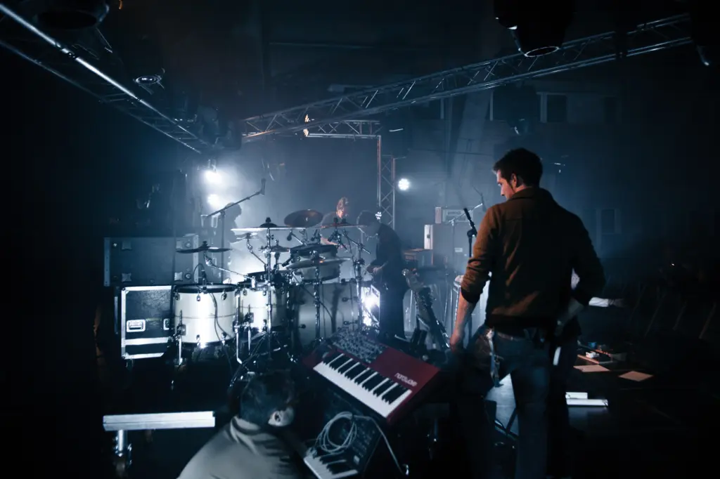 Musiker auf der Bühne mit Schlagzeug und Keyboard während eines Live-Auftritts.